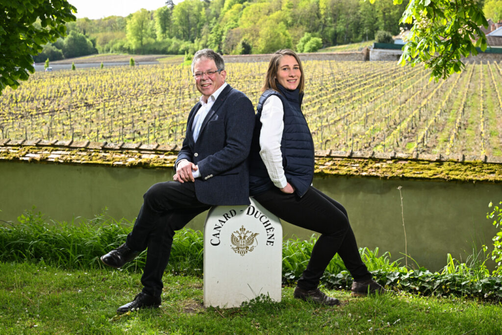 Cynthia Fossier et Laurent Fédou se tiennent devant un paysage de vignes.