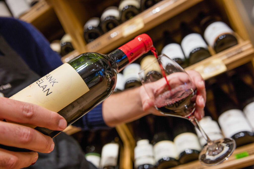 caviste verser du vin dans un verre bouteille bordelaise
